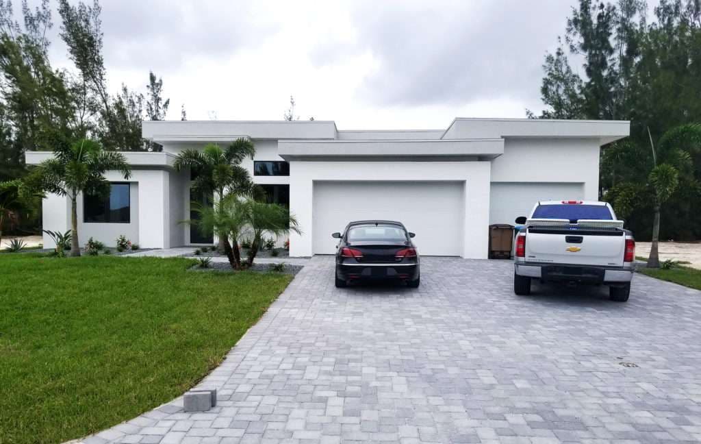 Modern single-family home with garage, two cars, and landscaped front yard.