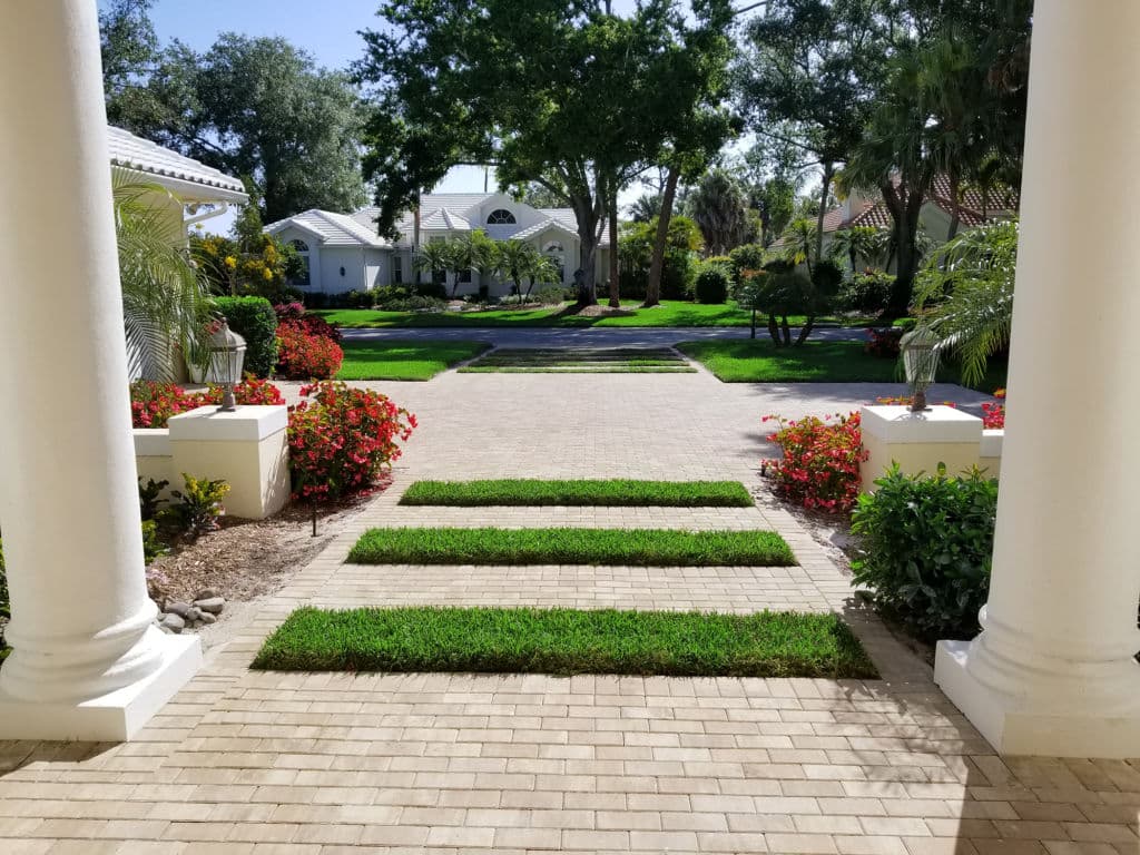 Lush garden pathway framed by flowers and greenery leading to a serene residential entrance.