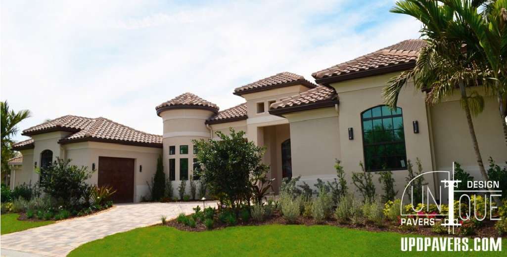 Modern luxury home with a tile roof, landscaped lawn, and elegant curb appeal.