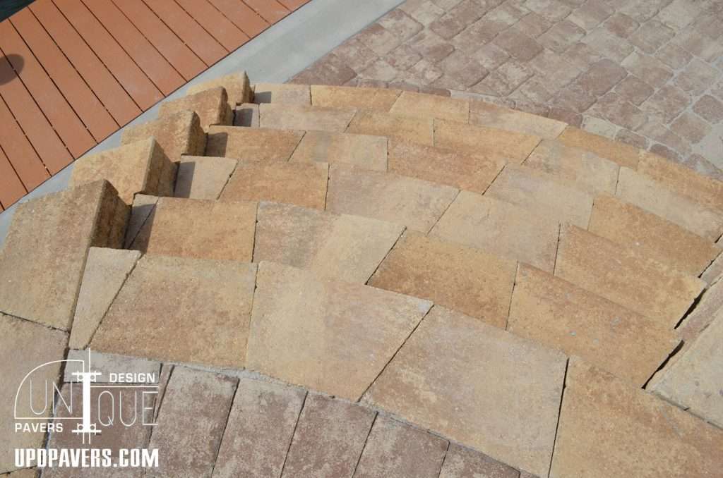 Curved stone steps with patterned pavers in a modern outdoor setting.