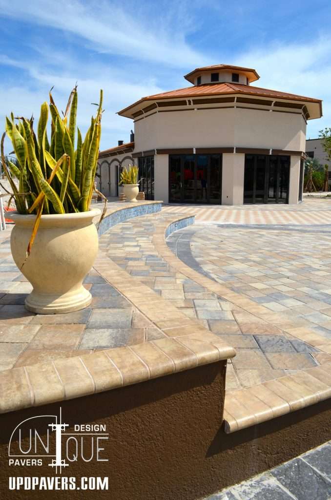 Modern outdoor patio featuring unique pavers and landscaping with decorative planters.
