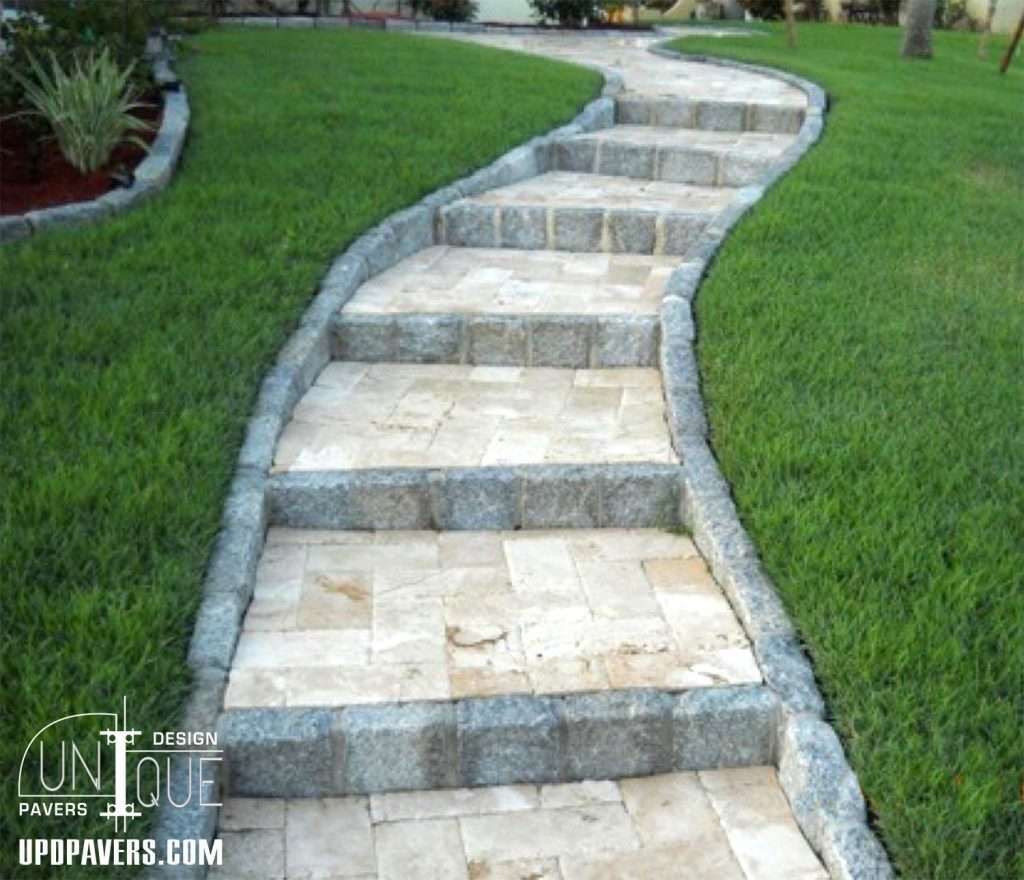 Curved stone pathway with grass on either side, enhancing outdoor landscaping design.