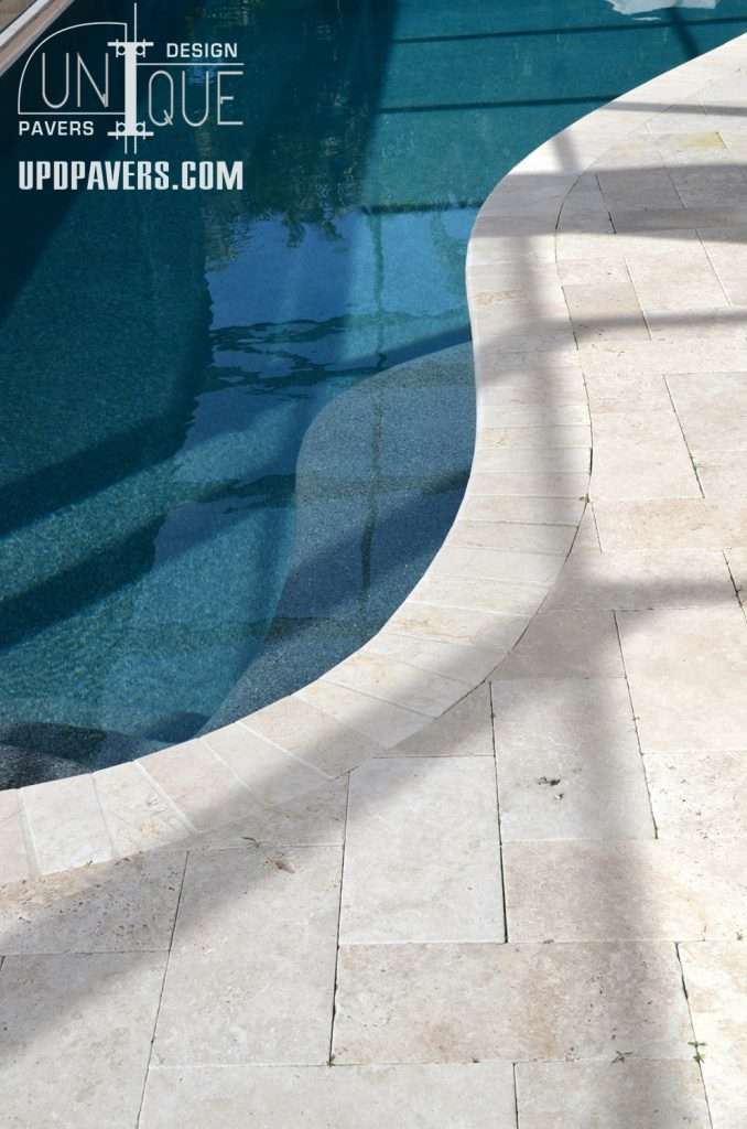 Stylish pool with unique pavers and clear water, showcasing elegant outdoor design.