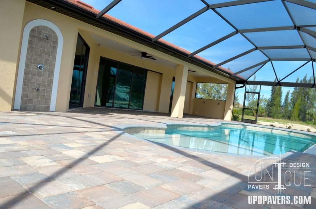 Modern patio with a screened enclosure, swimming pool, and elegant paver flooring.