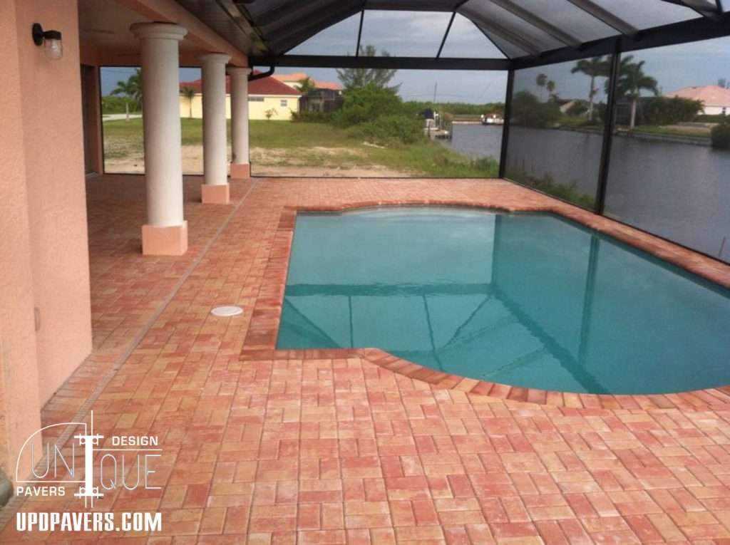 Pool area with paver patio and screened enclosure by Unique Pavers Design.
