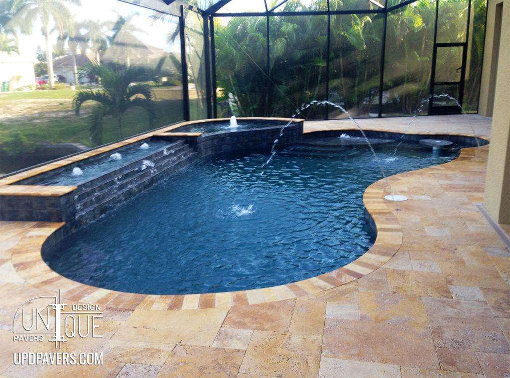 Elegant curved pool design with water features in a tropical backyard setting.