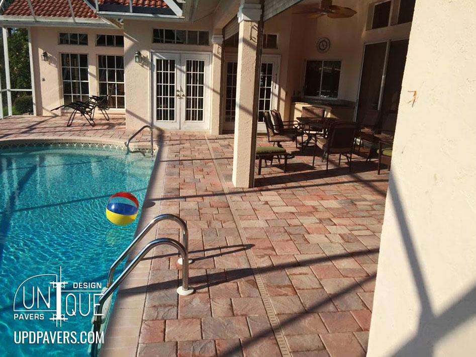 Poolside patio with pavers, lounge chairs, and swimming pool in a sunny outdoor setting.