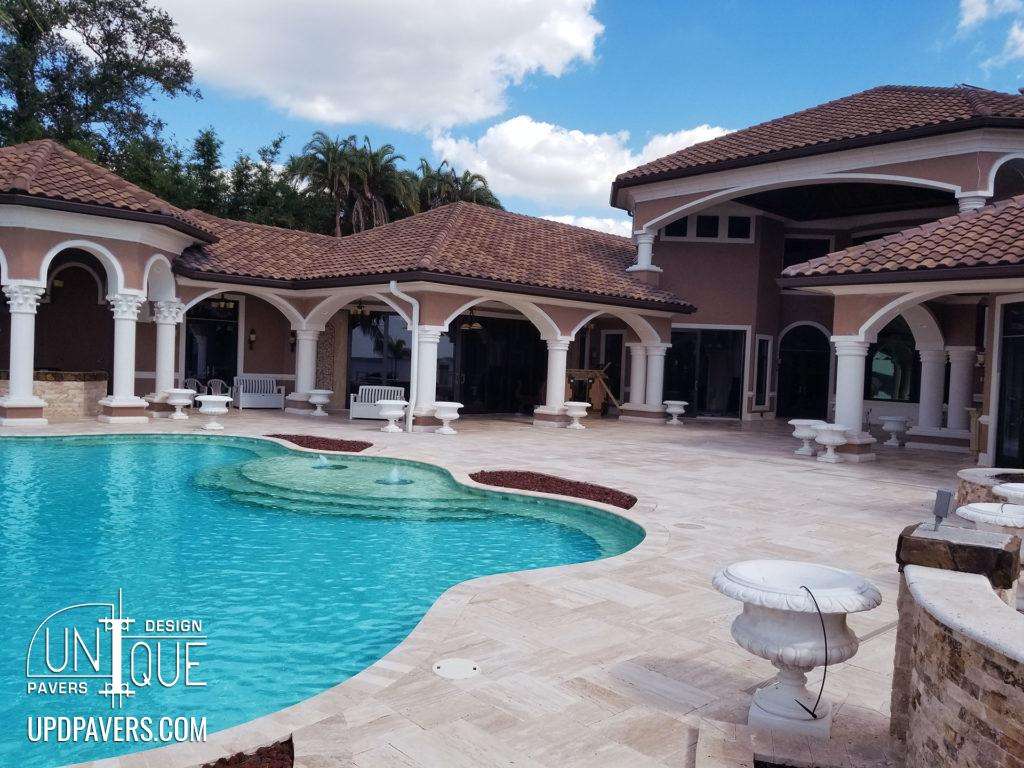 Luxury outdoor pool with spacious patio and elegant architecture in a sunny setting.