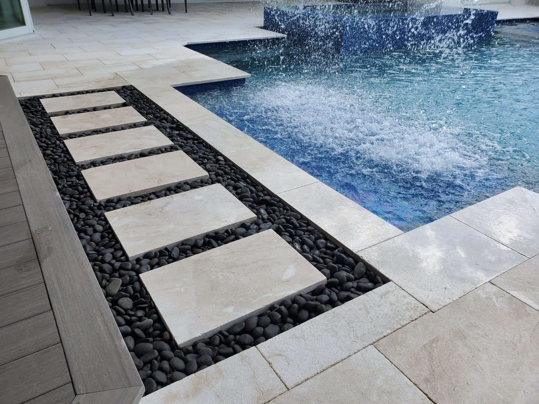 Elegant outdoor pool area featuring stone stepping stones and a water feature.