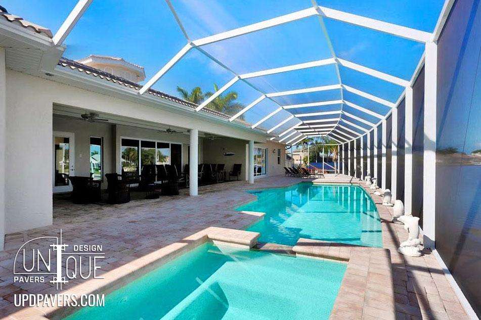 Elegant pool area with covered patio, modern paving, and serene water features.