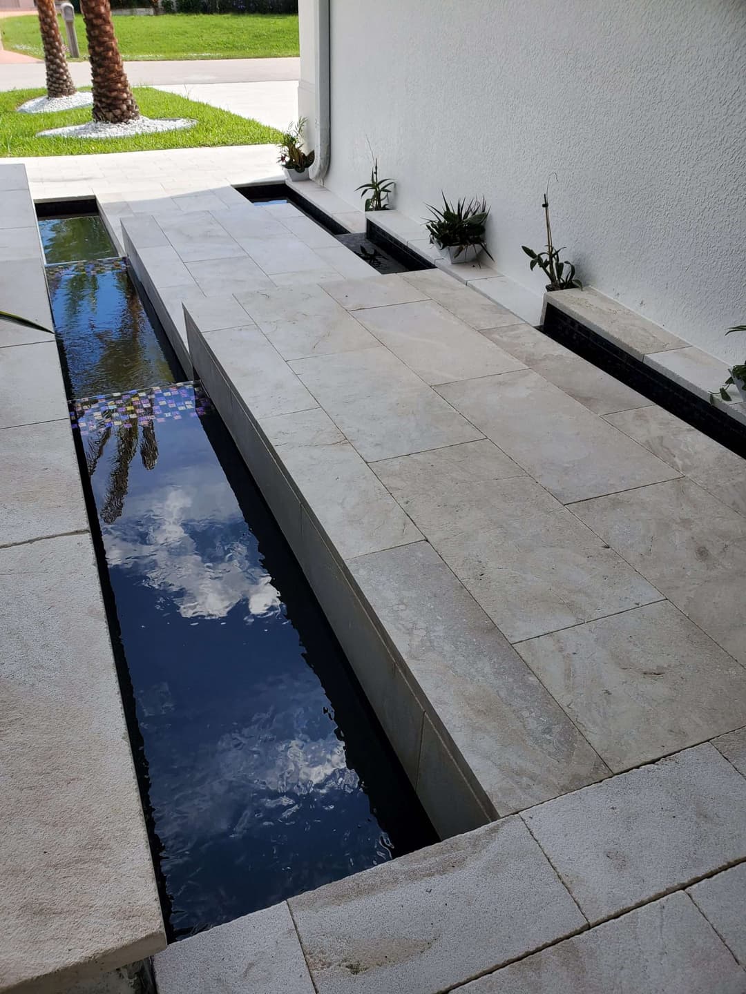 Modern outdoor courtyard design with stone pathways and tranquil water features.
