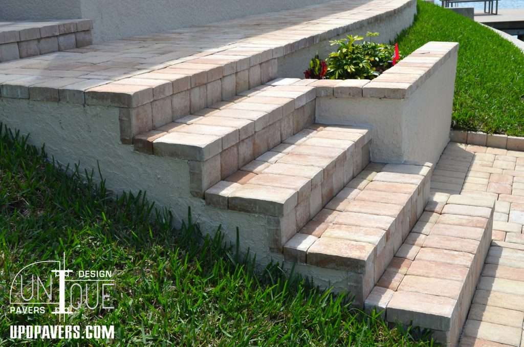 Elegant patio stairs featuring brick pavers, surrounded by lush greenery and flowers.