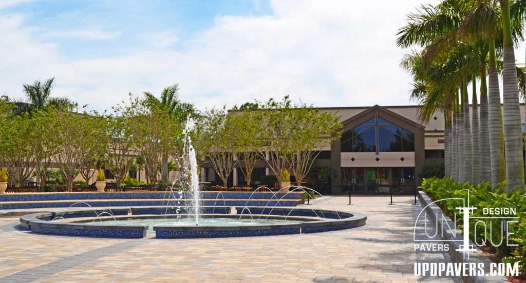 Elegant outdoor plaza with fountain and palm trees near Unique Pavers design center.