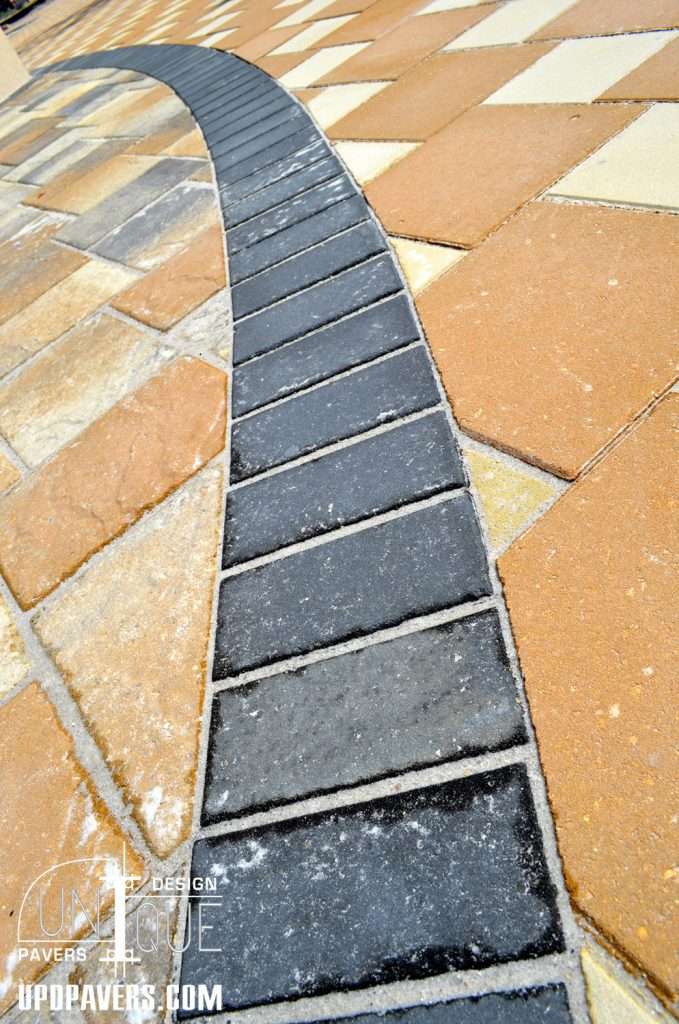 Curved black and tan paver walkway design showcasing unique geometric patterns.