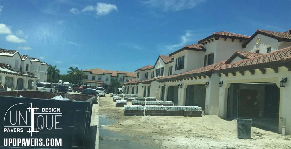 Construction site of luxury homes with paver stones in bright, sunny weather. Unique design elements.