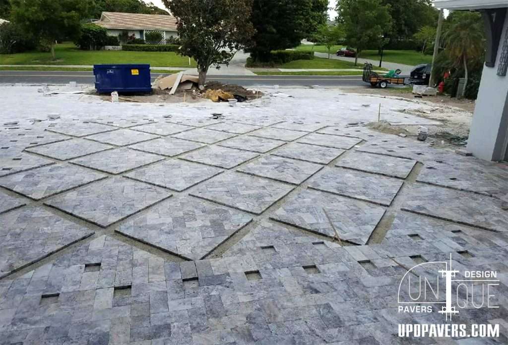 Paver installation in progress, showcasing a patterned layout for outdoor space renovation.