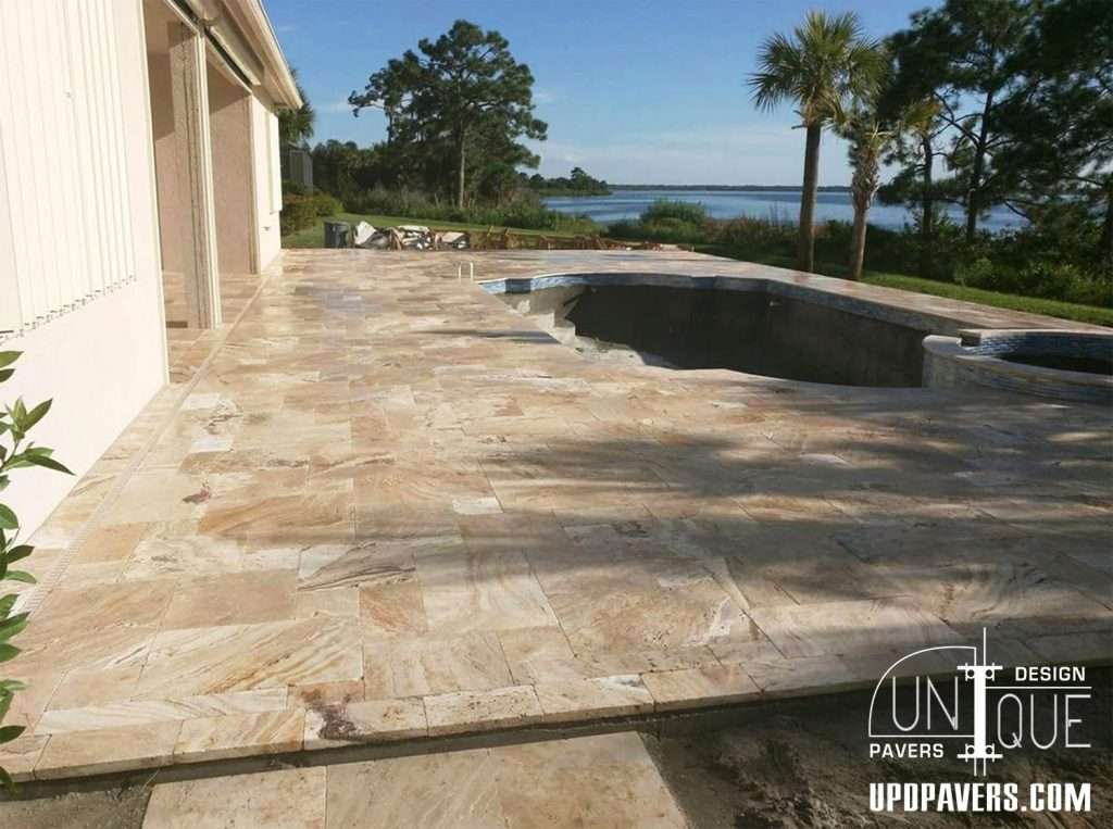 Elegant patio featuring natural stone pavers, overlooking a scenic water view.
