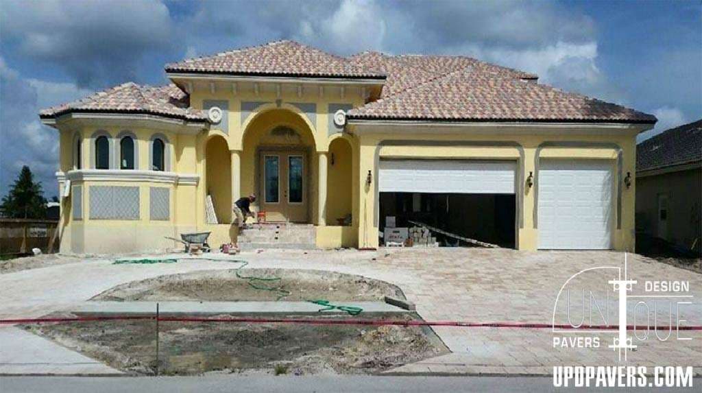 Newly constructed luxury home with a tiled roof, garage, and landscaped entrance.