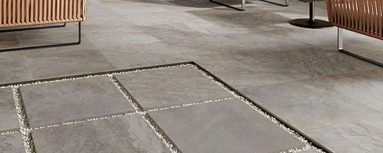 Modern indoor space featuring sleek gray tiles with decorative gravel inlaid design.