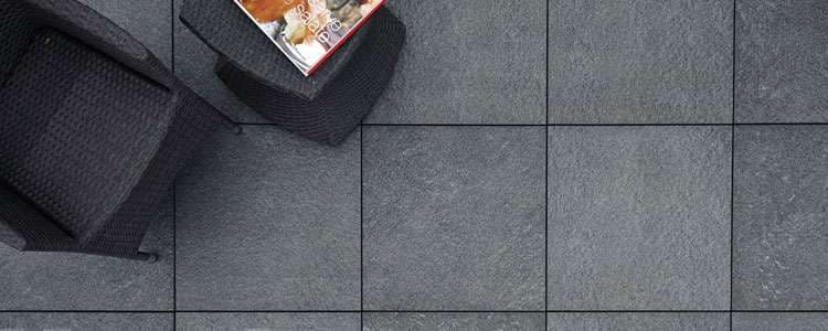 Gray stone patio tiles with woven chairs and a magazine on a table. Perfect for outdoor spaces.