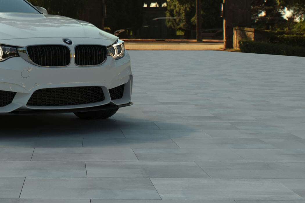White BMW on a grey tiled surface with trees in the background, showcasing modern design.