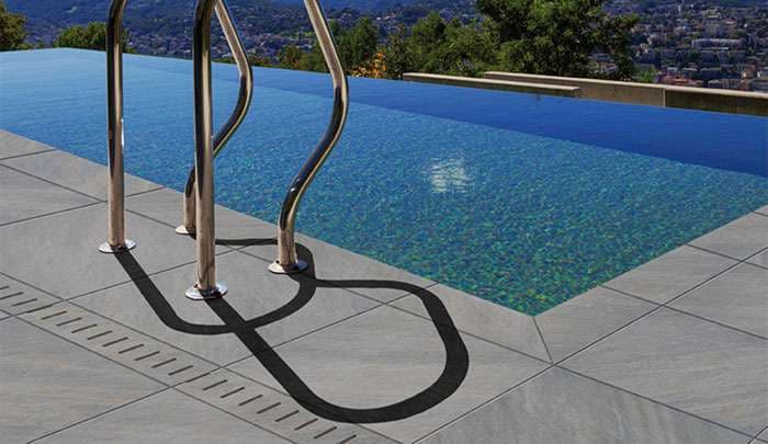 Modern infinity pool with sleek metal ladder and stunning landscape view.