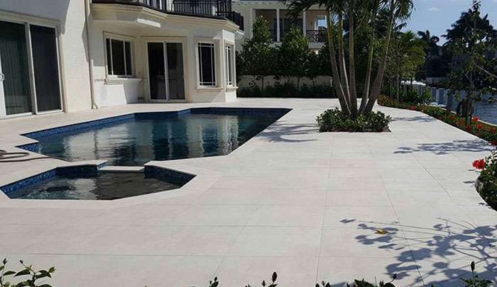 Luxury home exterior with swimming pool and spa, surrounded by landscaped garden.