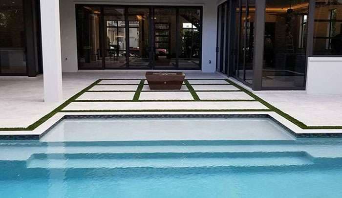 Modern backyard with a swimming pool, stylish patio, and landscaped paths. Perfect for relaxation.