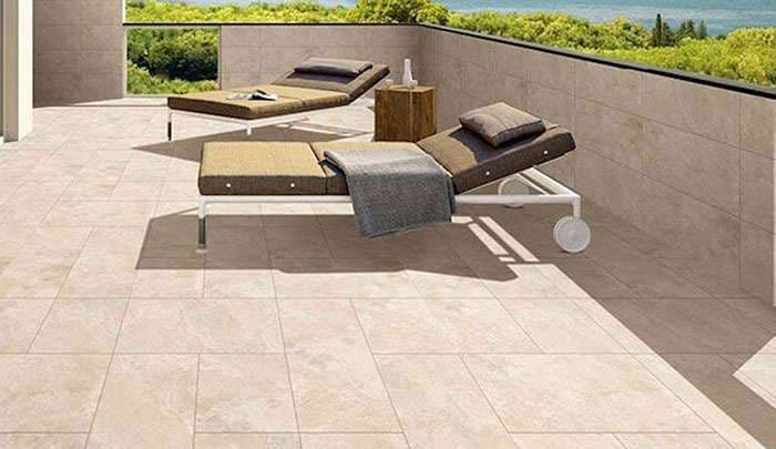 Modern patio with two loungers, a side table, and scenic green landscape in background.