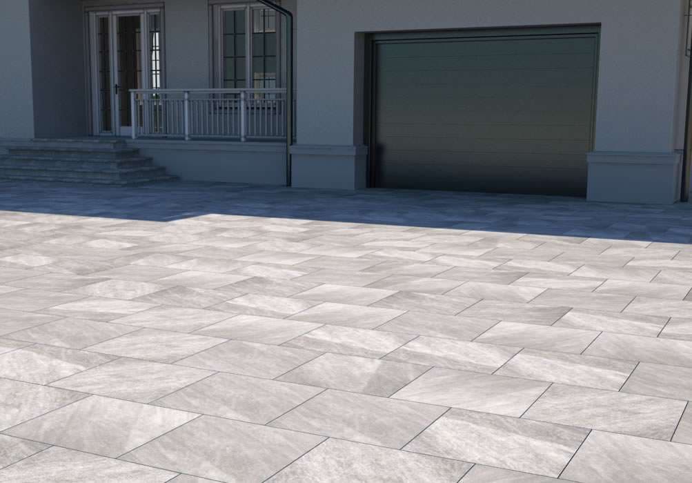 Gray patterned outdoor pavers lead to a modern house entrance and garage.