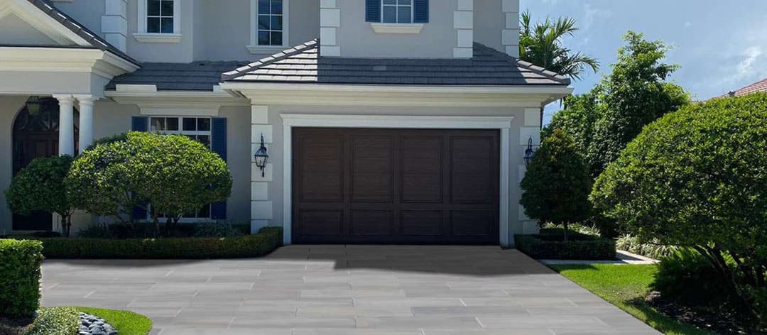 Modern home exterior with lush greenery, a stylish garage, and a sleek driveway.