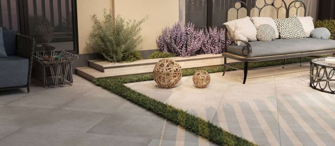 Modern outdoor patio featuring stylish seating, decorative spheres, and lush greenery.