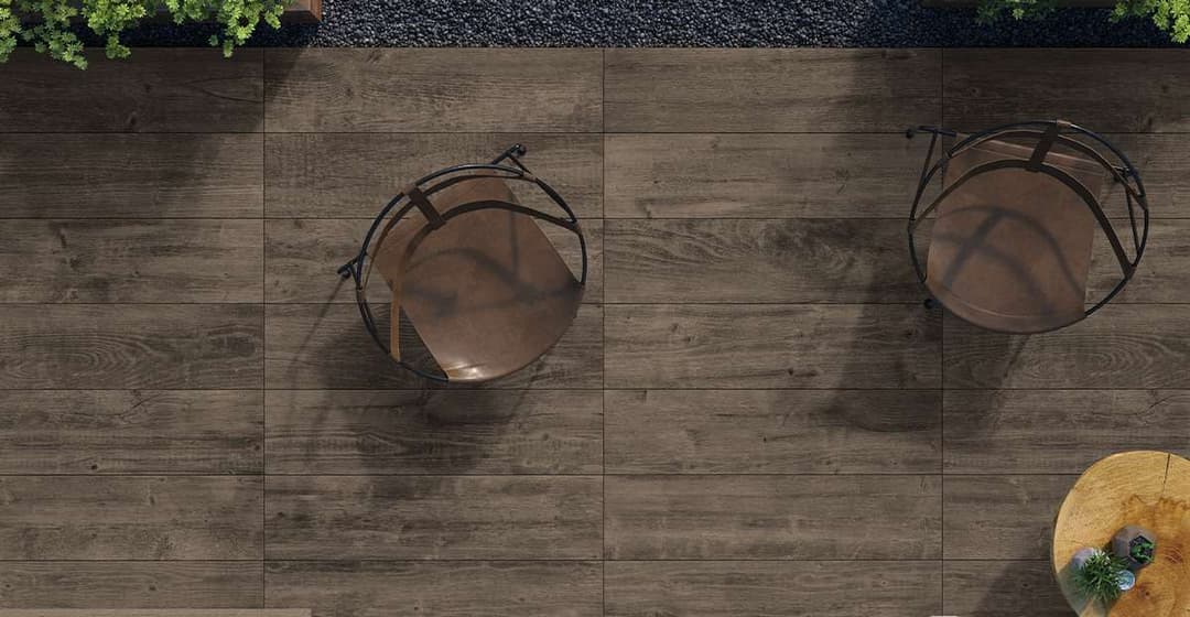 Wooden tile patio overview with two modern chairs and decorative plants.