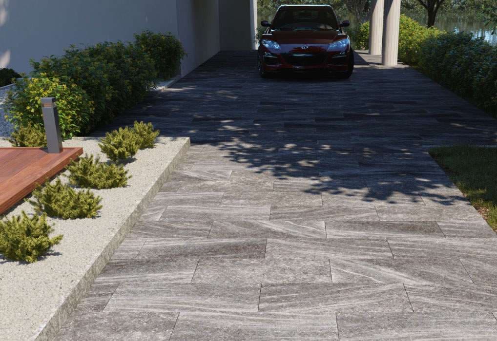 Modern driveway with gray stone paving and sleek black car under soft lighting.