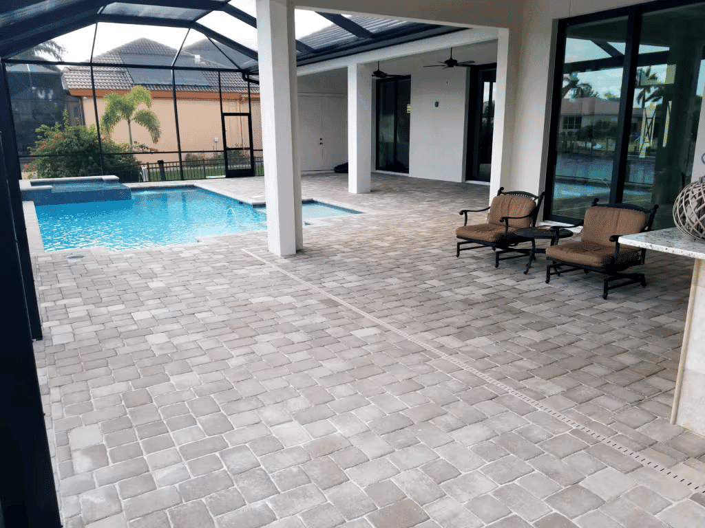 Luxury outdoor patio with pool, pavers, and seating area in a modern home.